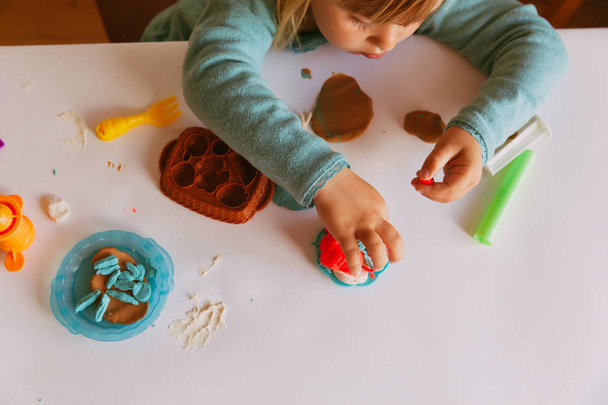 Enfant jouant avec des formes de moulage en argile
 - Photo, image