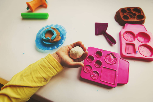 Niño jugando con formas de moldeo de arcilla
 - Foto, Imagen