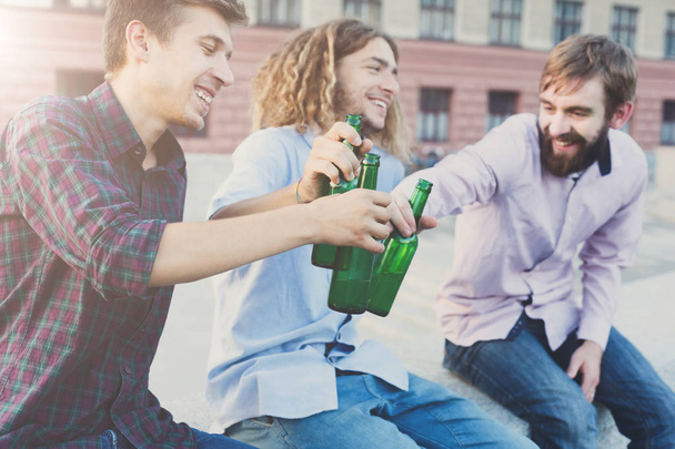 Happy friends cheers with beer outdoor - Foto, afbeelding