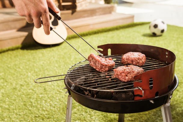 Person grilling burgers  - Foto, afbeelding