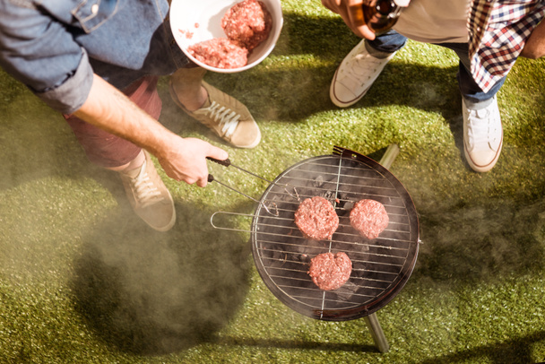 Young men grilling burgers  - Photo, Image