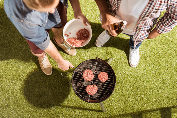 Young men grilling burgers  - Photo, Image