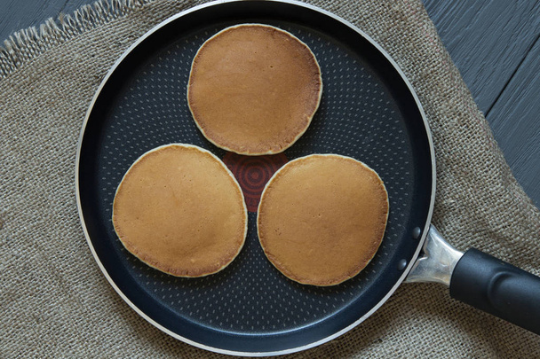 Three pancakes in a frying pan on a sackcloth - Foto, Bild