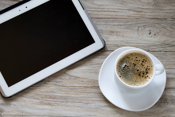 Φλιτζάνι καφέ και tablet σε φόντο ξύλινη - Φωτογραφία, εικόνα