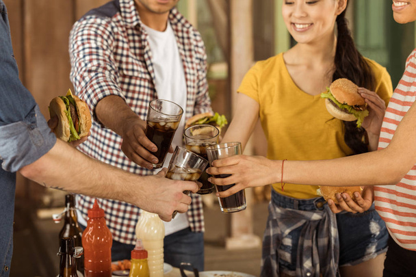 friends clinking with glasses of cola at picnic - Photo, Image