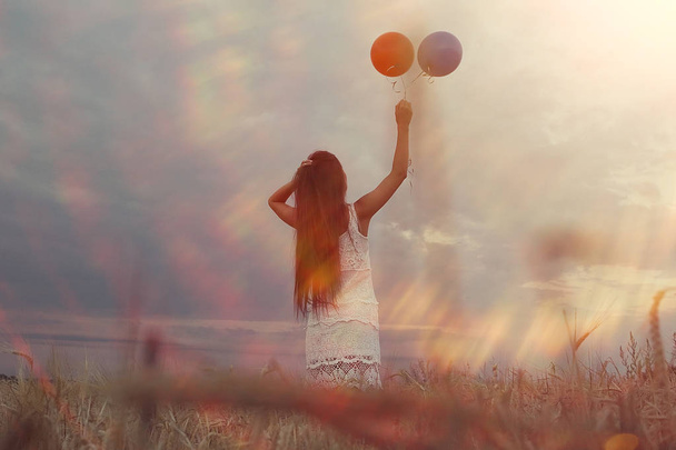 mujer en campo de trigo con globos voladores
 - Foto, Imagen