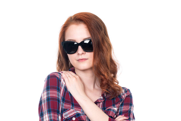 Close-up portrait of a red-haired beautiful woman wearing sunglasses - Foto, Bild