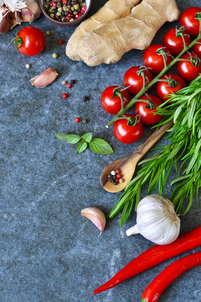 Gıda arka plan mermer bir zemin üzerine farklı malzemelerle. Kiraz domates, biberiye, sarımsak, biber, limon. Üstten Görünüm. - Fotoğraf, Görsel