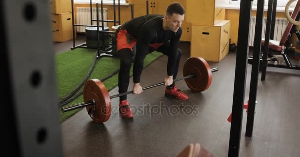 Strong man doing barbell snatch exercise at the gym - Filmati, video