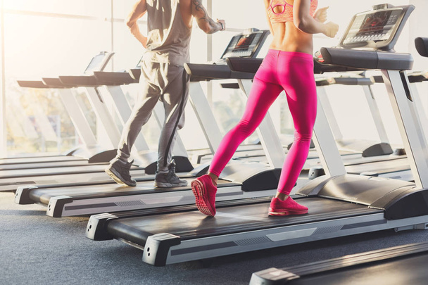 Man and woman, couple in gym on treadmills - Foto, imagen