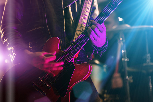A rocker is playing guitar on stage. - Fotó, kép