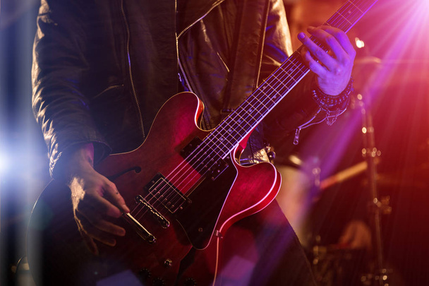 A rocker is playing guitar on stage. - Фото, зображення