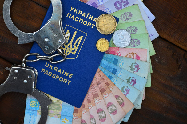 Una fotografia di un passaporto straniero ucraino, una certa quantità di denaro ucraino e manette della polizia
 - Foto, immagini