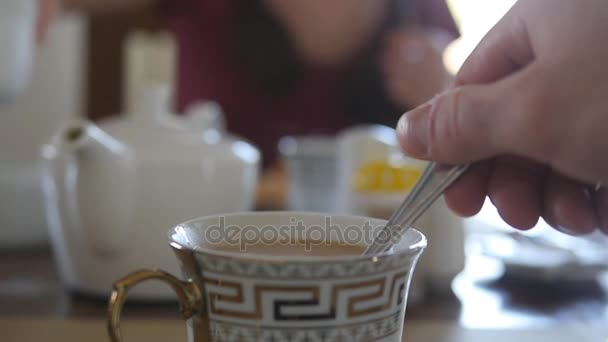 Férfi kézzel keverjük a cukor és tej egy csésze forró kávé vagy tea. Lassú mozgás közelről - Felvétel, videó