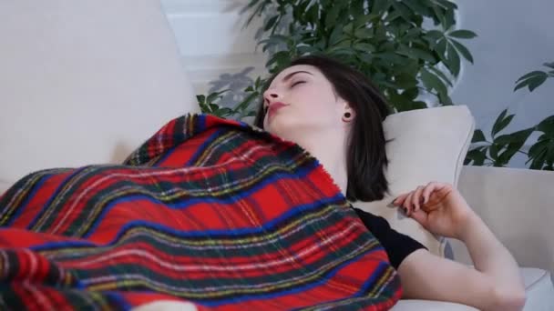 young woman sleeping on the sofa at home - Video, Çekim