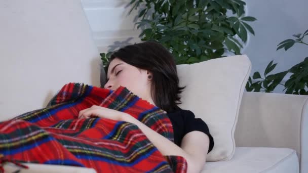 young woman sleeping on the sofa at home - Video, Çekim