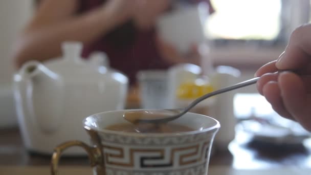 Женская рука перемешивает сахар или молоко в чашке горячего кофе или чая. Медленное движение
 - Кадры, видео