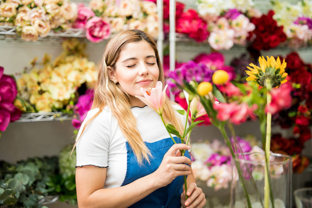 Młoda kobieta wąchająca kwiat - Zdjęcie, obraz