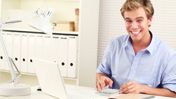 Dedicado joven empresario feliz trabajando desde su oficina en el hogar
 - Metraje, vídeo