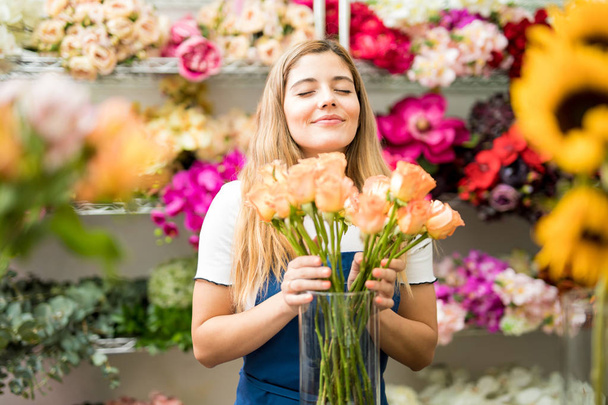 Жіночий флорист пахне купою троянд
 - Фото, зображення