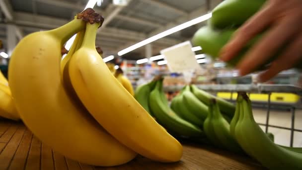 Kupující vybírá banány na čítač supermarketu - Záběry, video