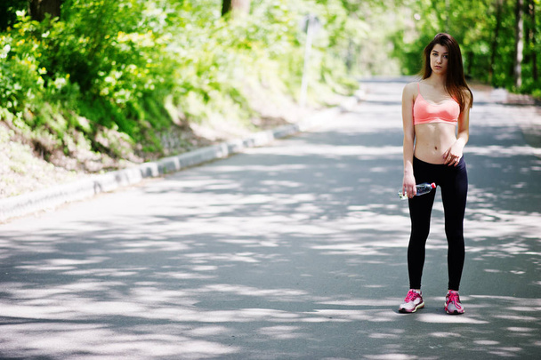 Fitness sport girl in sportswear with bottle of water in the str - Foto, Bild