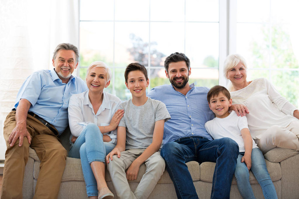 Famiglia sorridente sul divano
 - Foto, immagini