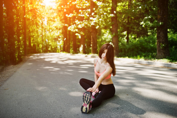 Fitness sport girl in sportswear sitting in road at park, outdoo - Фото, зображення