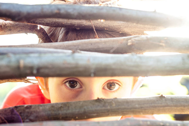 Bange jongen kijkt op de hek-gleuf - Foto, afbeelding