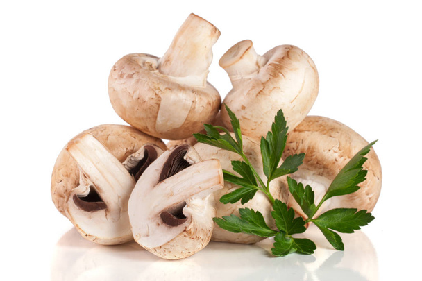 A bunch of champignon mushrooms with leaf parsley isolated on white background - Fotó, kép