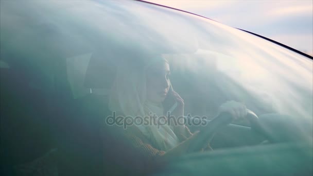 Młoda kobieta Arab jest rozmowy przez telefon z mężem w jej samochód osobowy - Materiał filmowy, wideo