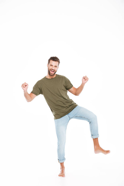Happy young man standing isolated over white background - Foto, Bild