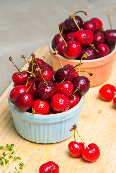 Red ripe cherries in ceramic bowls - Fotografie, Obrázek