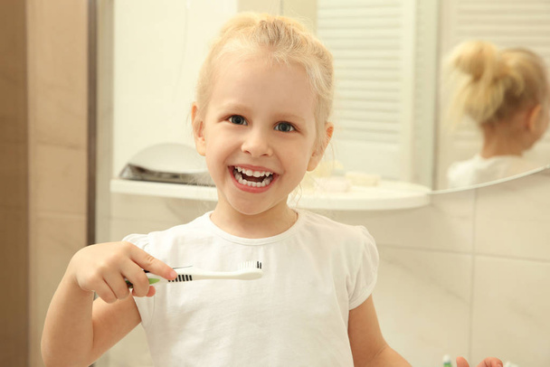 Little girl holding toothbrush  - Fotografie, Obrázek