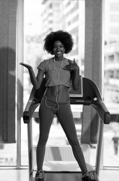 afro american woman running on a treadmill - Valokuva, kuva