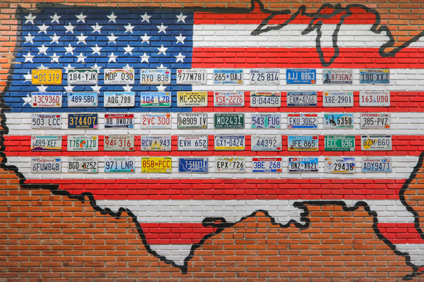 Ratchaburi, Tajlandia - 15 grudnia 2016 roku: Różne stare amerykańskie tablice rejestracyjne z różnych państw na ścianie budynku z cegły w Tajlandii. - Zdjęcie, obraz