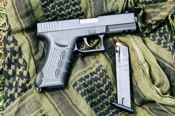Un pistolet avec un magazine sur fond vert
 - Photo, image