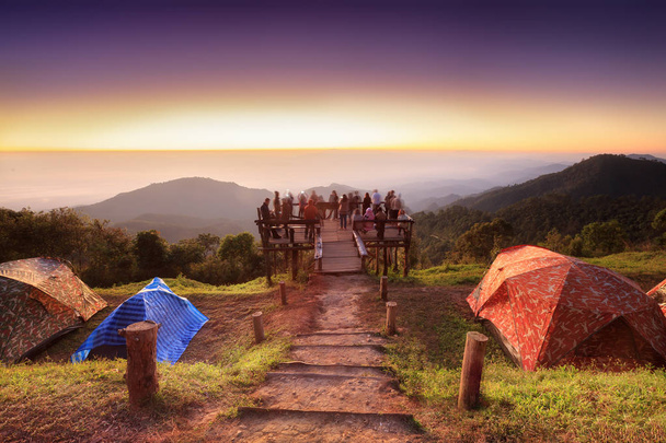 I turisti non identificati stanno godendo al vecchio punto di vista di legno sulla cima della montagna durante l'alba. - (Lunga esposizione / Sfocatura movimento
) - Foto, immagini