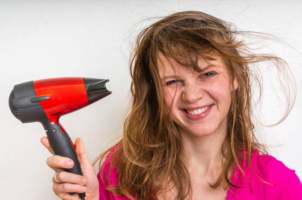 Fashion girl with hair dryer dries her hair - Photo, Image