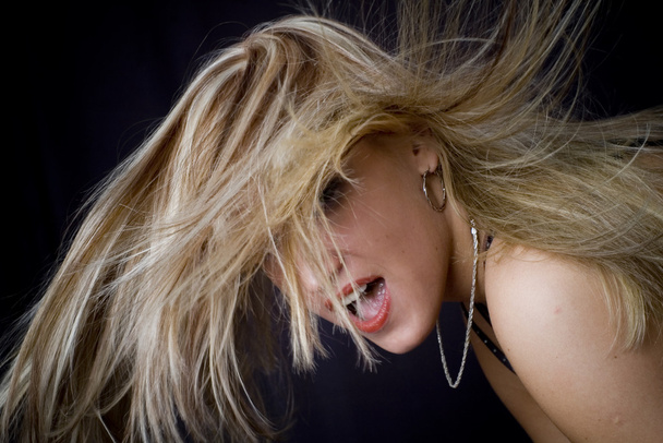 Blond posing and fan blows in her face - Fotó, kép