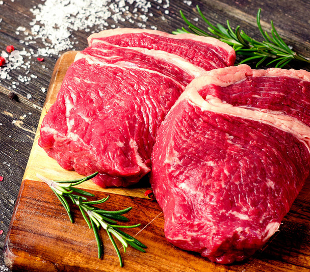 Raw beef steaks with rosemary - Фото, зображення