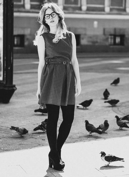 blond girl and pigeons, lifestyle and fashion, black and white picture - Photo, image