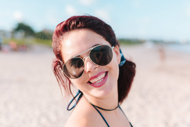Close up portrait of young redhead woman on the beach - Фото, изображение