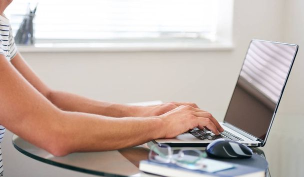 Cropped image of composed mans hands typing on a laptop - Fotó, kép