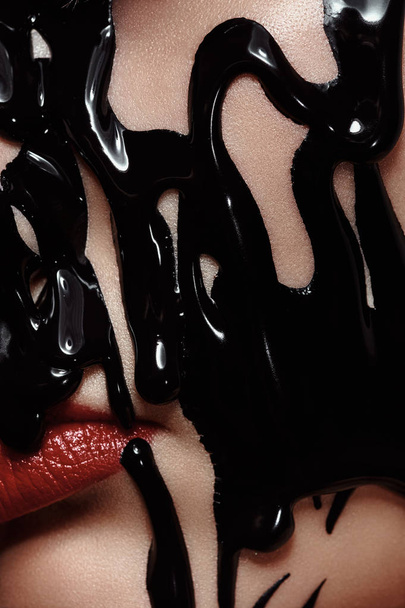 Black liquid Paint on Face of beautiful Woman - Photo, image