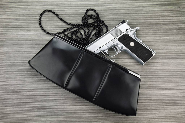 Женская сумка с спрятанным пистолетом, пистолет и аксессуары, выпавшие из женского кошелька
. - Фото, изображение