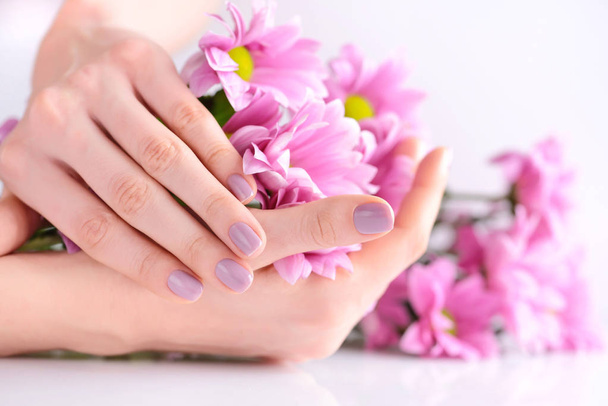 Ręce kobiety z różowy manicure paznokcie i różowe kwiaty - Zdjęcie, obraz