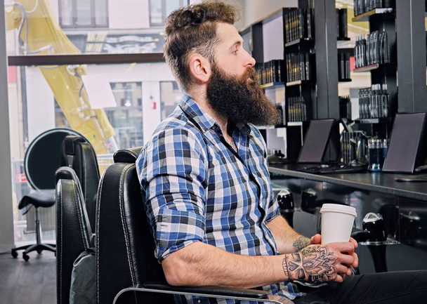 Un homme boit du café dans un salon de coiffure
 - Photo, image