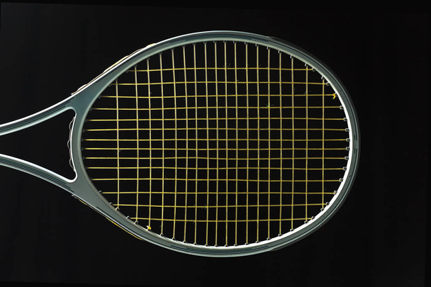 Raqueta de tenis sobre fondo negro
 - Foto, imagen