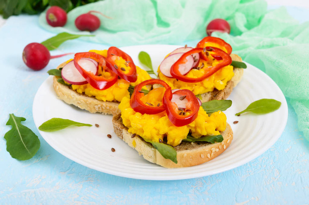 Sandwich met roerei, rucola, radijs, paprika kapi en lijnzaad - Foto, afbeelding